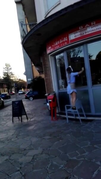 Guarda il culo a ragazza che pulisce vetro del bar