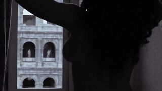 Tette alla finestra guardando il Colosseo