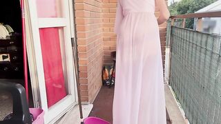 Casalinga pulisce il balcone con vestaglia trasparente