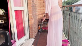 Casalinga pulisce il balcone con vestaglia trasparente