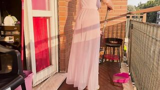 Casalinga pulisce il balcone con vestaglia trasparente