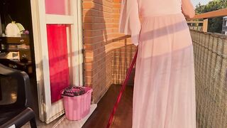 Casalinga pulisce il balcone con vestaglia trasparente