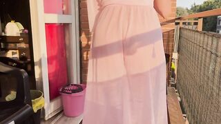 Casalinga pulisce il balcone con vestaglia trasparente