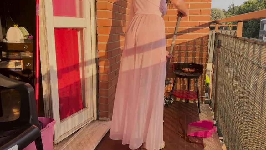 Casalinga pulisce il balcone con vestaglia trasparente
